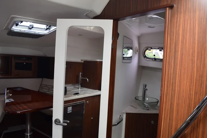 Slide: The Image of 2022 Pursuit OS 355 Offshore interior with wood finish, kitchenette, and bathroom. - 377