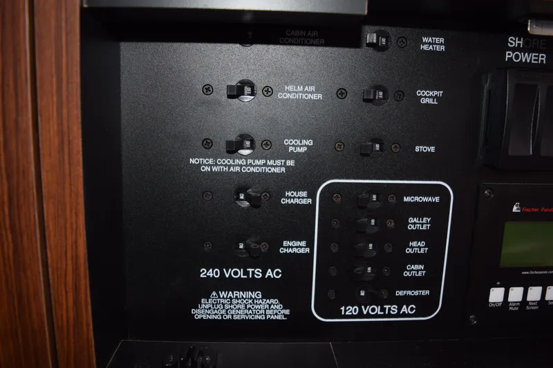 Slide: The Image of Control panel of a 2022 Pursuit OS 355 Offshore boat, showing electrical switches and warnings. - 411