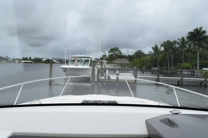 Slide: The Image of 2022 Pursuit OS 355 Offshore boat docked in a marina with cloudy skies. - 218