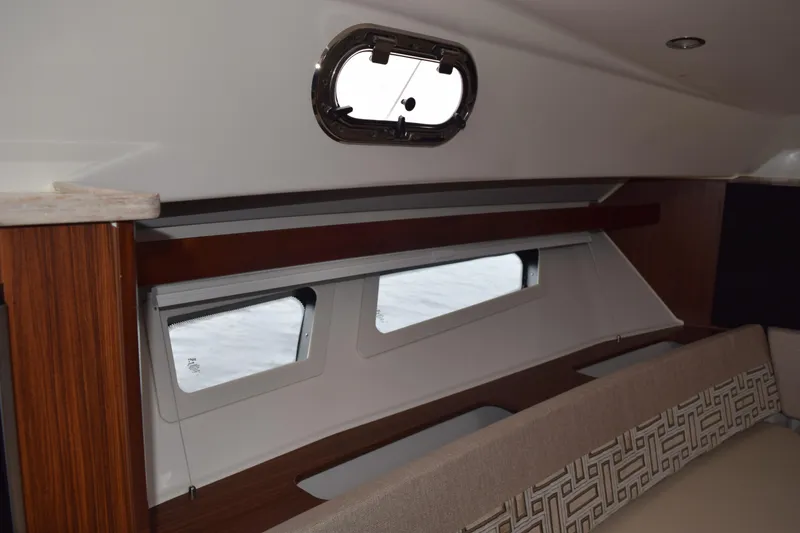 Slide: The Image of Interior view of 2022 Pursuit OS 355 Offshore boat cabin with windows and seating. - 395