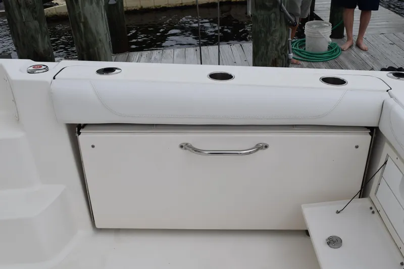 Slide: The Image of 2022 Pursuit OS 355 Offshore boat seating area with cup holders and storage. - 26