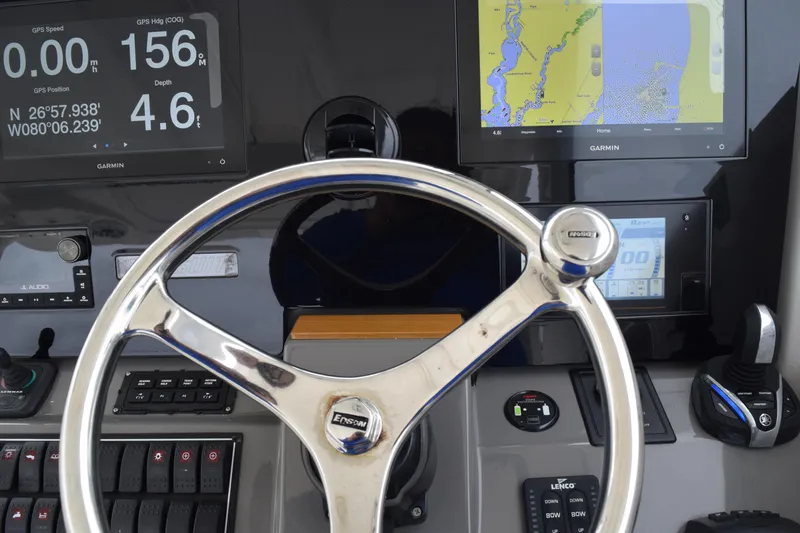 Slide: The Image of Steering wheel and dashboard of 2022 Pursuit OS 355 Offshore boat with navigation displays. - 301