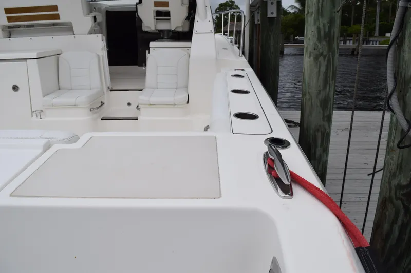 Slide: The Image of 2022 Pursuit OS 355 Offshore boat interior with seating and docked at marina. - 96
