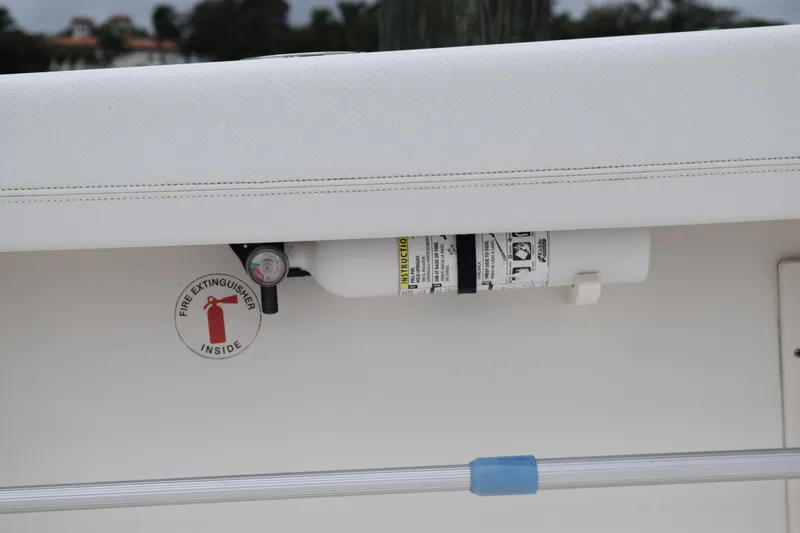 Slide: The Image of Fire extinguisher on 2022 Pursuit OS 355 Offshore boat, secured under a white panel. - 116