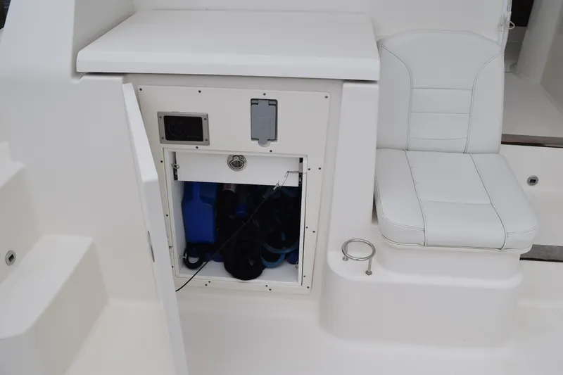 Slide: The Image of 2022 Pursuit OS 355 Offshore boat interior with storage compartment and cushioned seat. - 36