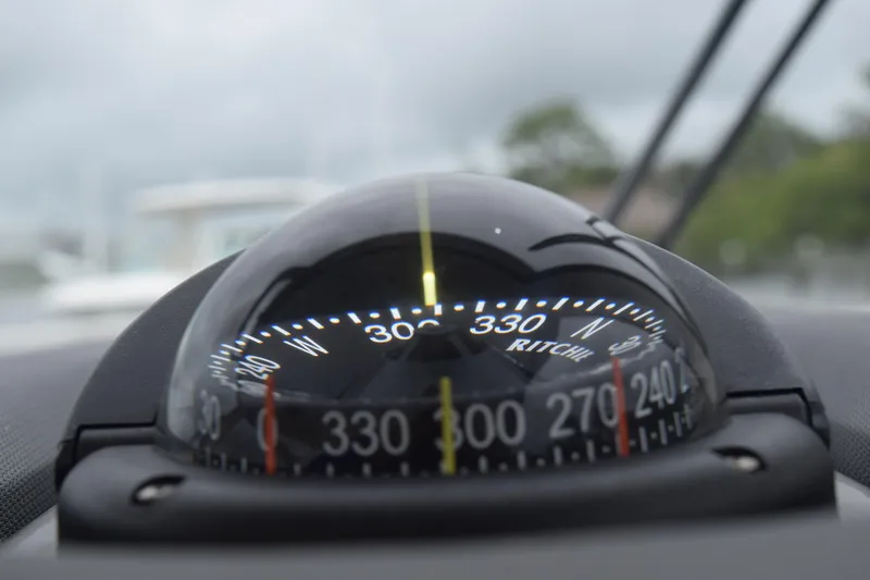 Slide: The Image of Compass on 2022 Pursuit OS 355 Offshore boat, showing navigation directions. - 215