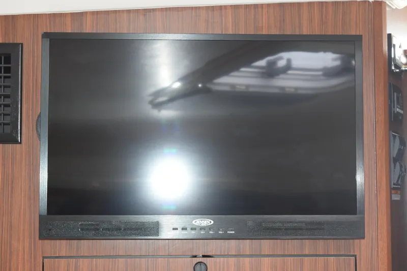 Slide: The Image of Flat-screen TV mounted on wood panel inside 2022 Pursuit OS 355 Offshore boat. - 398