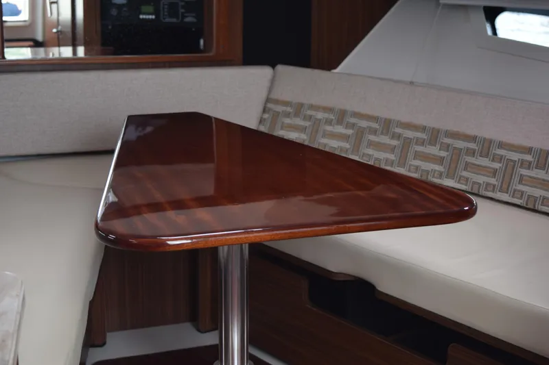 Slide: The Image of Interior of 2022 Pursuit OS 355 Offshore with polished wooden table and cushioned seating. - 434