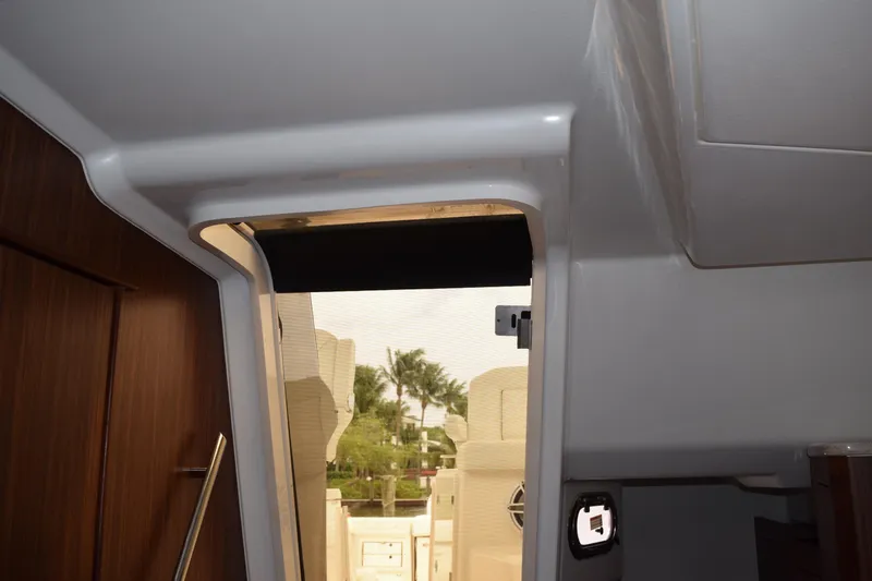 Slide: The Image of Interior view of 2022 Pursuit OS 355 Offshore boat, showcasing cabin entrance and wood paneling. - 362