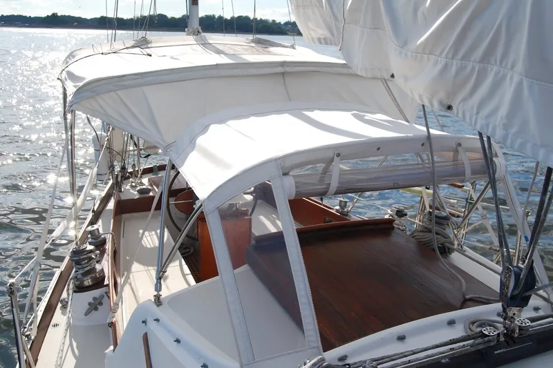 Slide: The Image of 1981 Bristol 40 Yawl sailboat with white canopy on calm water. - 23