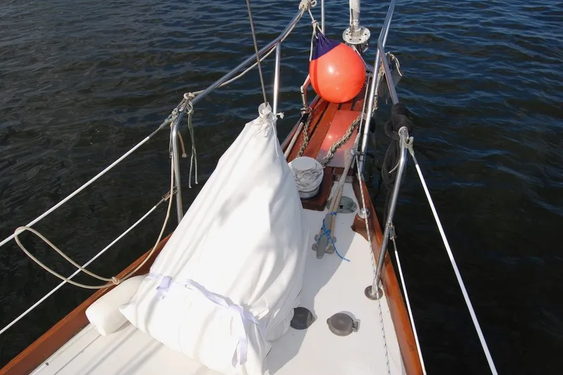 Slide: The Image of 1981 Bristol 40 Yawl sailboat deck with ropes and buoy on calm water. - 30