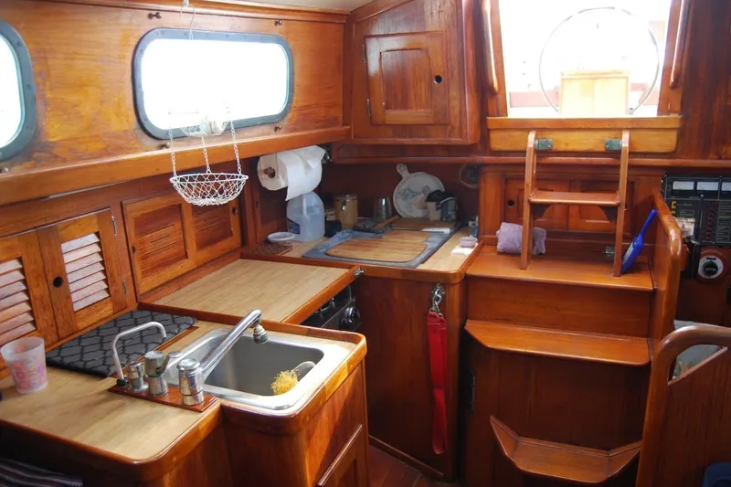 Slide: The Image of Interior of 1981 Bristol 40 Yawl sailboat with wooden cabinetry and compact kitchen area. - 37