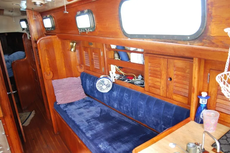 Slide: The Image of Interior of 1981 Bristol 40 Yawl with wooden paneling and blue cushioned seating. - 39