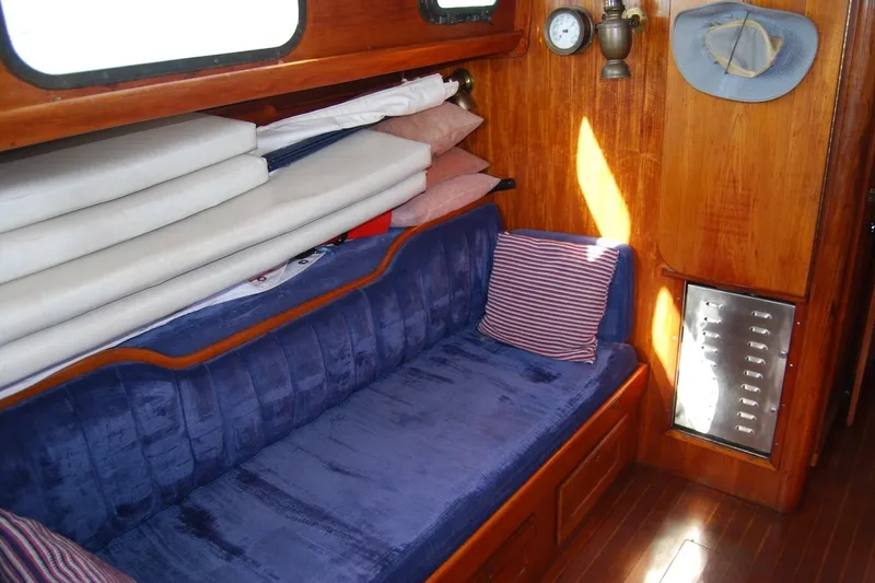 Slide: The Image of Interior of 1981 Bristol 40 Yawl with blue seating and wooden paneling. - 38