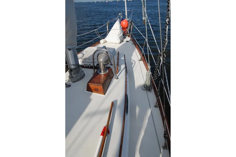 Slide: The Image of 1981 Bristol 40 Yawl sailboat deck with ropes and winch, sailing on calm waters. - 31
