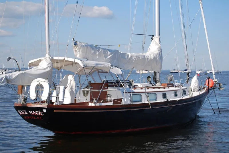Slide: The Image of 1981 Bristol 40 Yawl sailboat on calm water, with sails furled and clear sky. - 13