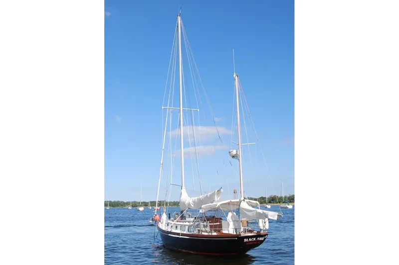 Slide: The Image of 1981 Bristol 40 Yawl sailboat on calm water under clear blue sky. - 10
