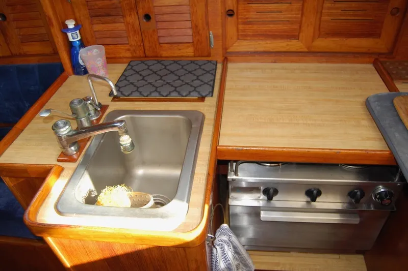 Slide: The Image of 1981 Bristol 40 Yawl kitchen with sink, stove, and wooden cabinetry. - 40