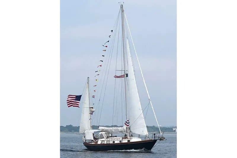 The Image of 1981 Bristol 40 Yawl sailing with flags and American flag on open water. - 0