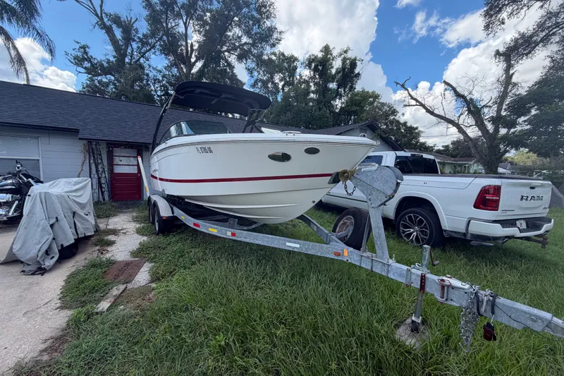 Slide: The Image of 2022 Regal LS2 boat on trailer beside white RAM truck in residential driveway. - 5