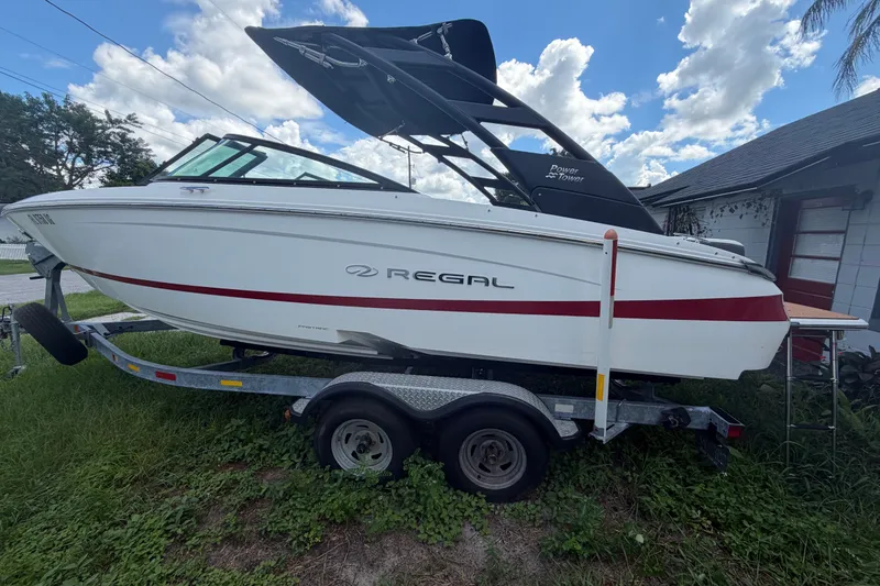 Slide: The Image of 2022 Regal LS2 boat on trailer, parked outdoors under a cloudy sky. - 1