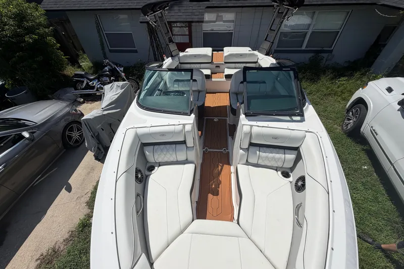 Slide: The Image of 2022 Regal LS2 boat with white interior and wooden deck, parked outdoors. - 33