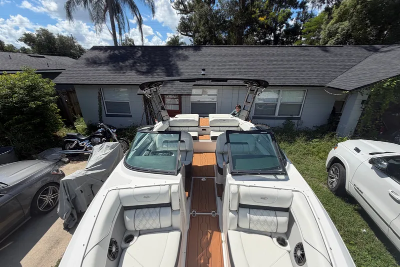 Slide: The Image of 2022 Regal LS2 boat parked in a residential driveway, surrounded by vehicles and greenery. - 32