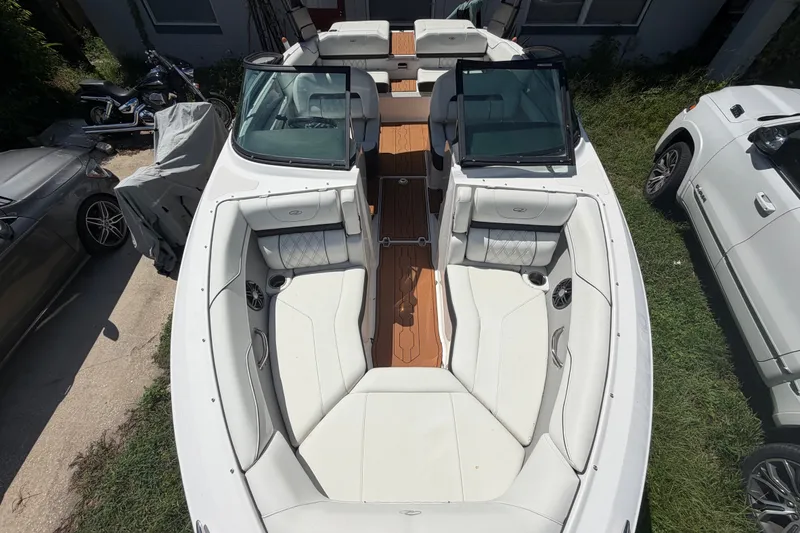 Slide: The Image of 2022 Regal LS2 boat with white seating and wooden deck, parked outdoors. - 31