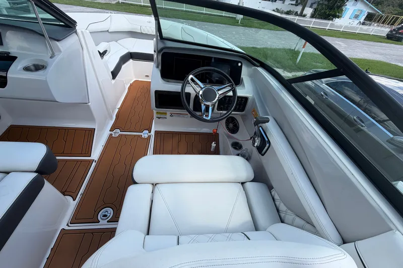 Slide: The Image of L'immagine mostra il cockpit di una barca Regal LS2 del 2022 con sedili bianchi e pavimento in legno. - 20
