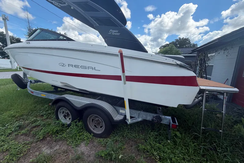 Slide: The Image of 2022 Regal LS2 boat on trailer, parked outdoors under a cloudy sky. - 3