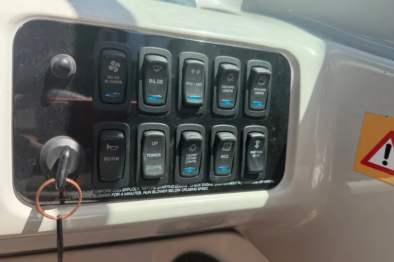 Slide: The Image of Control panel of a 2022 Regal LS2 boat with various switches and warning label. - 57