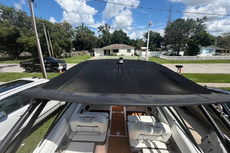 Slide: The Image of 2022 Regal LS2 boat with black canopy, parked on a residential street. - 46