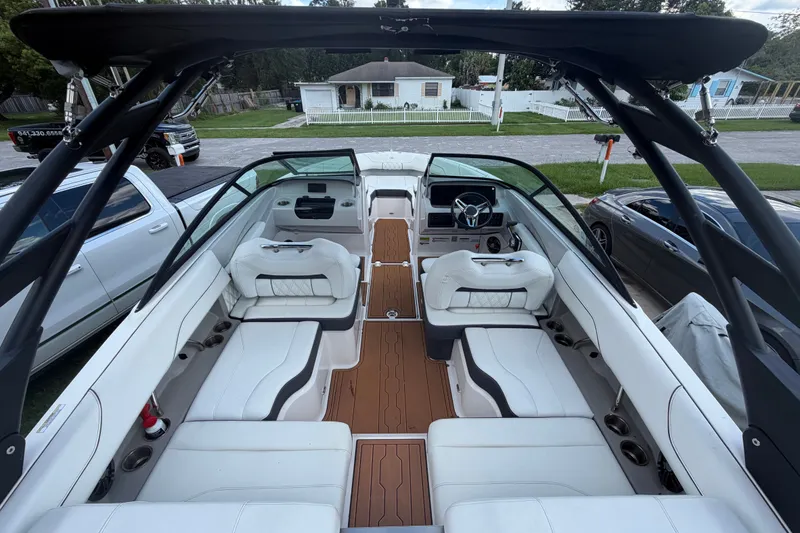 Slide: The Image of De afbeelding toont het interieur van een Regal LS2 boot uit 2022 met witte zitplaatsen en houten vloer. - 15