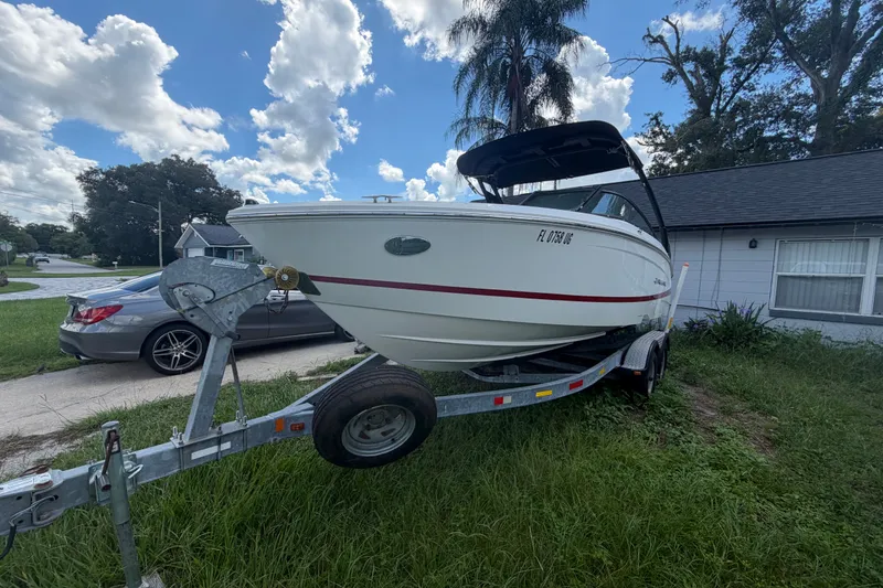 Slide: The Image of 2022 Regal LS2 boat on trailer, parked beside a house under a cloudy sky. - 4