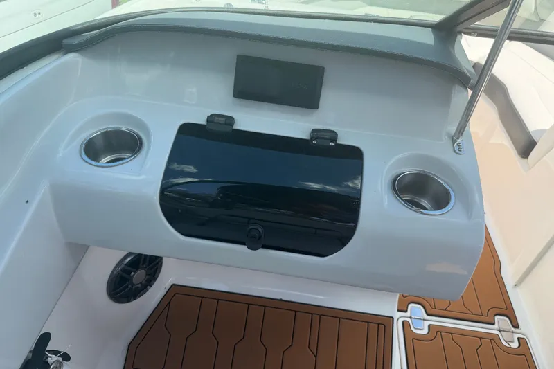 Slide: The Image of 2022 Regal LS2 boat dashboard with cup holders and storage compartment. - 51