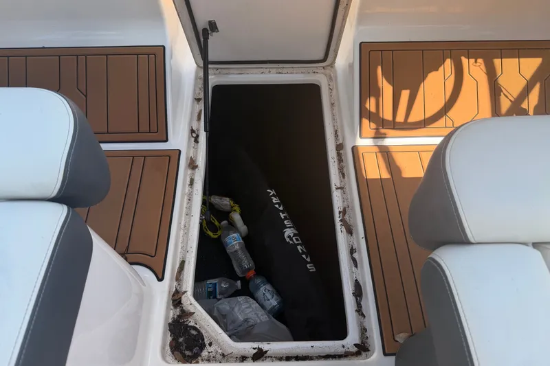 Slide: The Image of 2022 Regal LS2 boat storage compartment with debris and water bottles. - 28