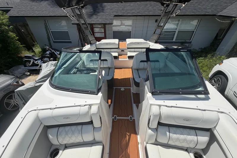 Slide: The Image of 2022 Regal LS2 boat with white leather seats and wooden flooring, parked outdoors. - 34