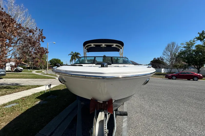 Slide: The Image of 2022 Regal LS2 boat on trailer, parked on suburban street under clear blue sky. - 15