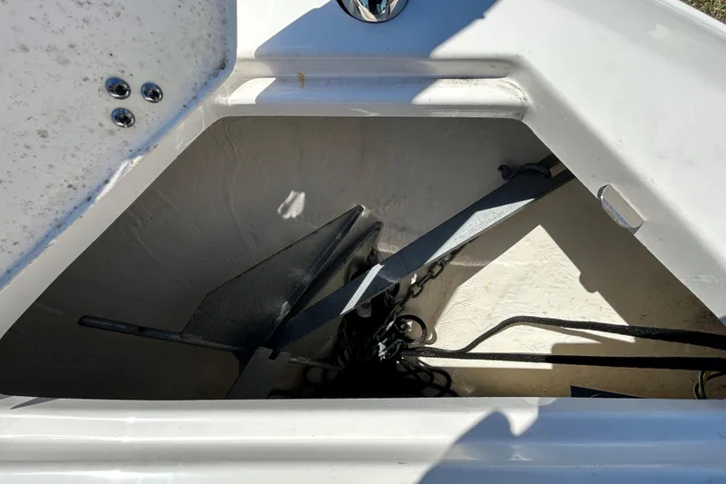 Slide: The Image of Anchor compartment of 2022 Regal LS2 boat, featuring a neatly stored anchor and chain. - 113