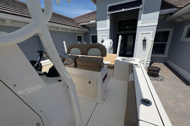 Slide: The Image of 2022 Sea Born LX22 Center Console boat parked in front of a modern house. - 14