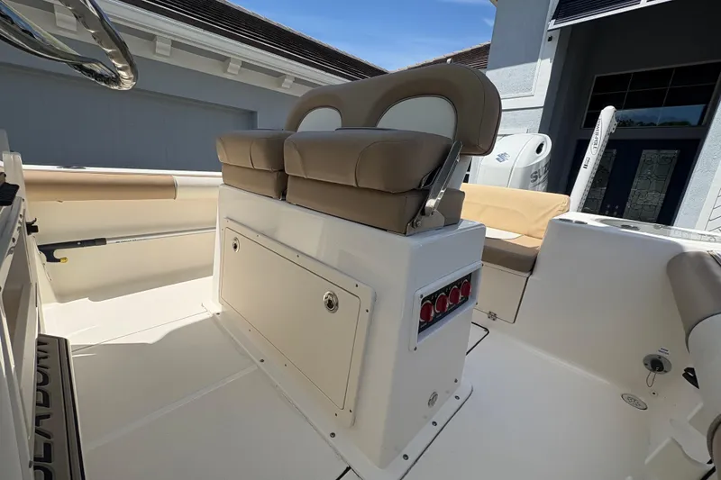 Slide: The Image of 2022 Sea Born LX22 Center Console boat interior with beige seating and control panel. - 15
