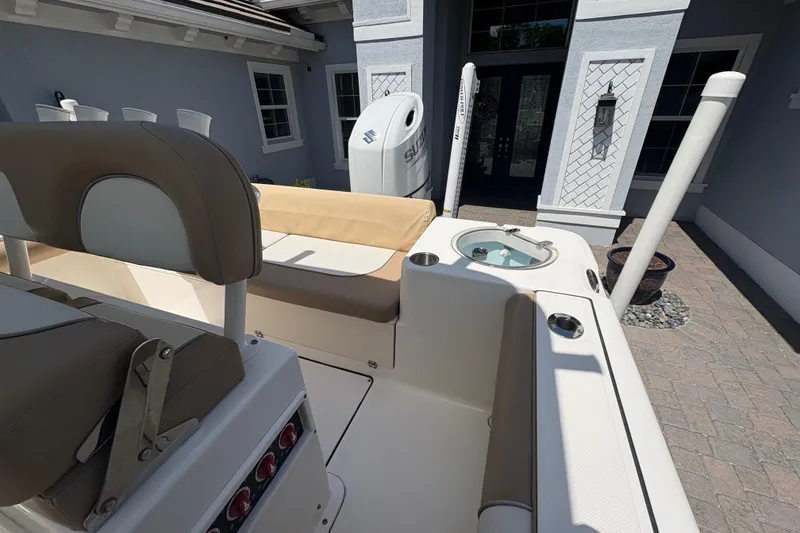 Slide: The Image of 2022 Sea Born LX22 Center Console boat with seating and storage, parked near a house. - 30
