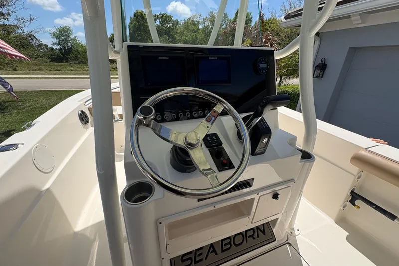 Slide: The Image of 2022 Sea Born LX22 Center Console boat interior with steering wheel and controls. - 16