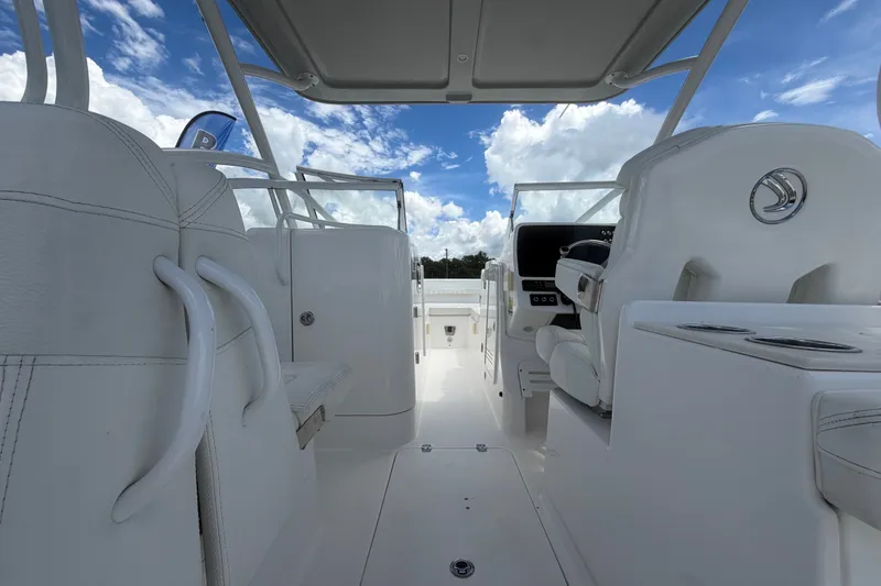 Slide: The Image of L'image montre le cockpit d'un bateau Edgewater 248CX Crossover avec des sièges blancs et un ciel bleu. - 22