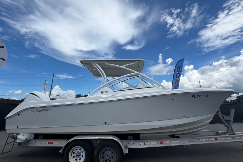Slide: The Image of Een Edgewater 248CX Crossover 2023 op een trailer, met een blauwe lucht op de achtergrond. - 1