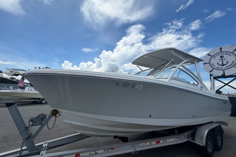 Slide: The Image of 2023 Edgewater 248CX Crossover boat on trailer under a bright blue sky. - 9