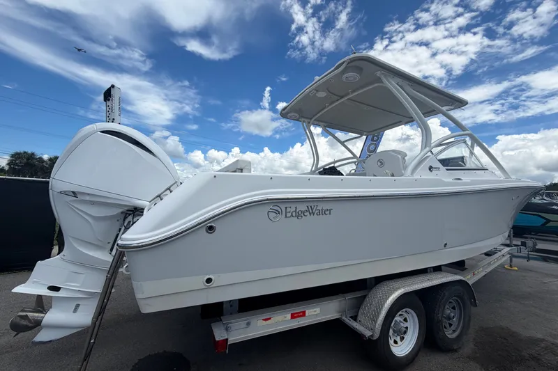 Slide: The Image of Un Edgewater 248CX Crossover 2023 sur une remorque, avec coque blanche et deux moteurs hors-bord. - 2