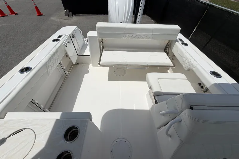 Slide: The Image of 2023 Edgewater 248CX Crossover boat interior with white seating and cup holders. - 78