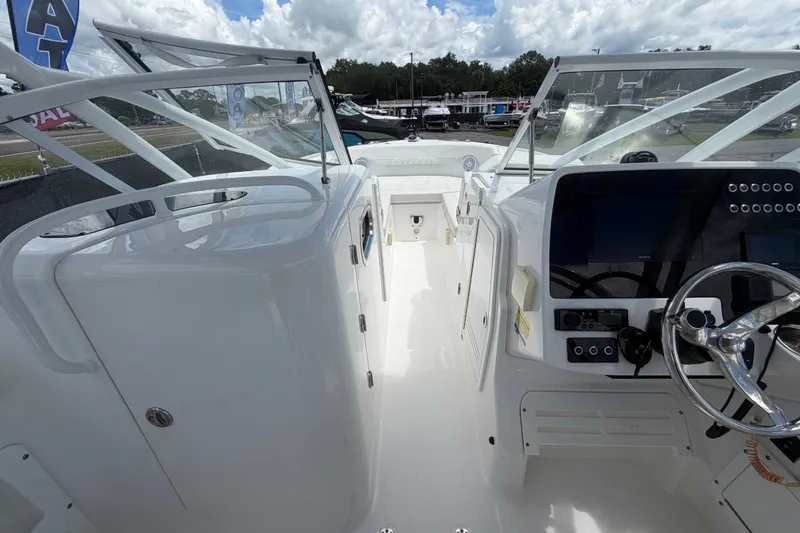 Slide: The Image of 2023 Edgewater 248CX Crossover boat interior with steering wheel and dashboard controls. - 54