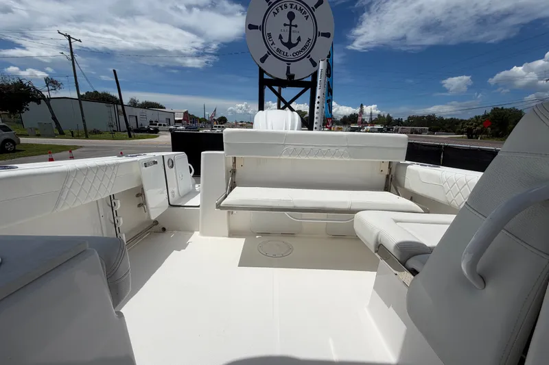 Slide: The Image of 2023 Edgewater 248CX Crossover boat interior with white seating and open deck. - 79
